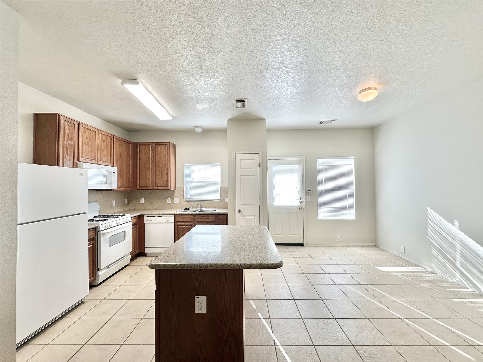 29709 Valley Center Drive Spring, TX 77386 - Photo 8 of 15 a kitchen with kitchen island a sink a stove a refrigerator cabinets and a window
