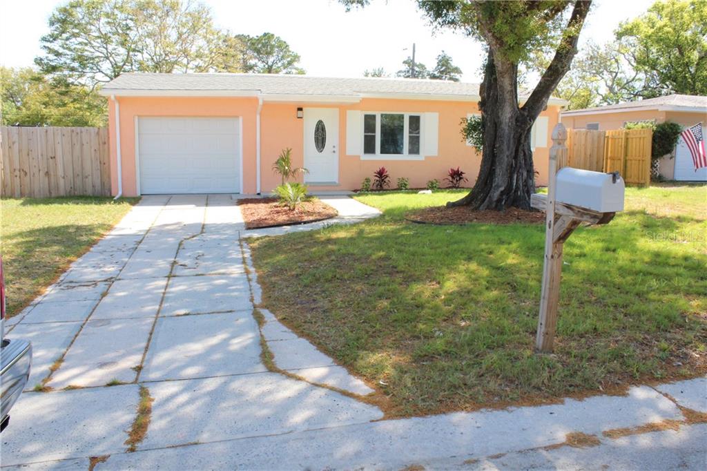 a view of a house with backyard and a tree