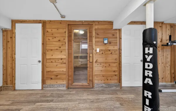 wooden floor and view of walk in closet with window