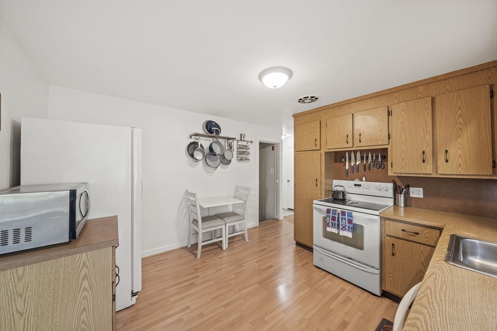 15 D Street Hull, MA 02045 - Photo 4 of 42 a kitchen with stainless steel appliances a stove a sink cabinets and a wooden floor