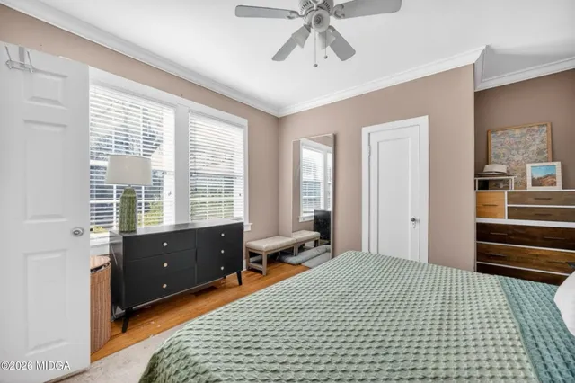 a bedroom with a bed and wooden floor