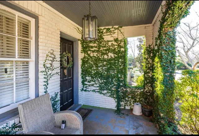 a view of porch with a table and chairs and potted plants
