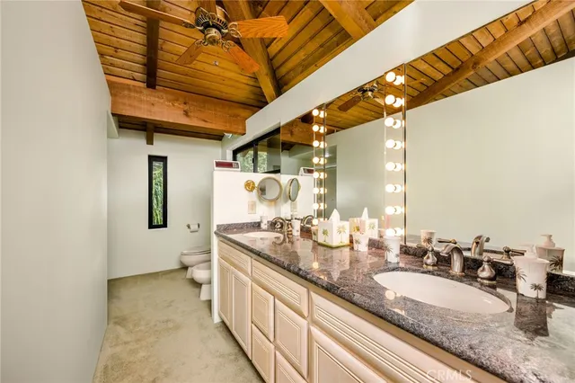 a en suite bathroom with a granite countertop sink and a mirror