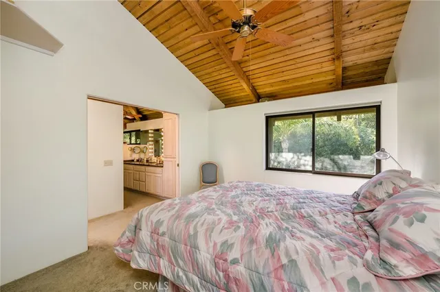 a bedroom with a bed and large windows