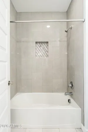 a spacious bathroom with a tub sink and mirror