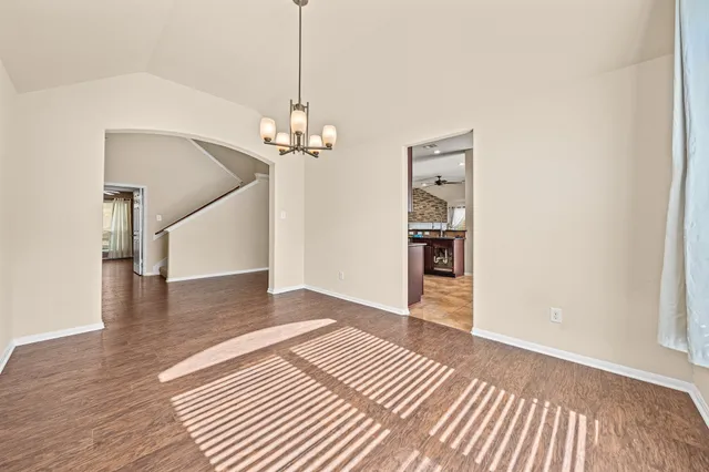 a view of a livingroom with wooden floor and staircase