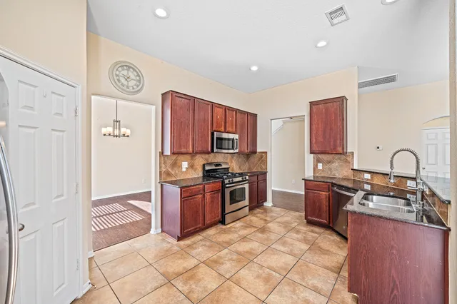 a kitchen with stainless steel appliances granite countertop a stove top oven a sink and dishwasher
