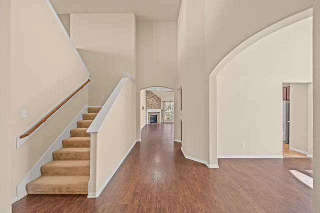 a view of a hallway with wooden floor and staircase
