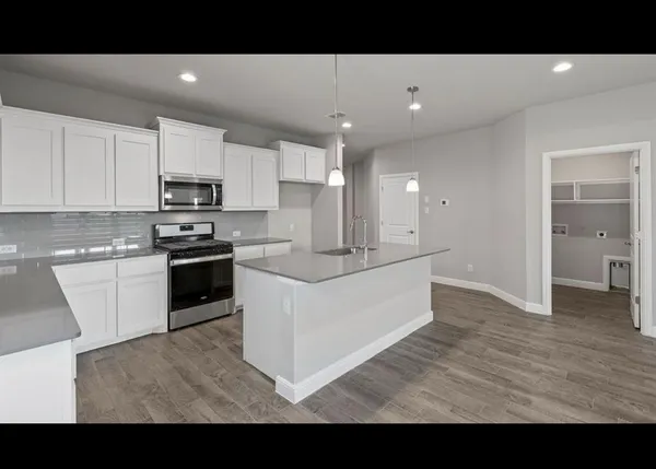 a living room with stainless steel appliances kitchen island granite countertop a sink and cabinets