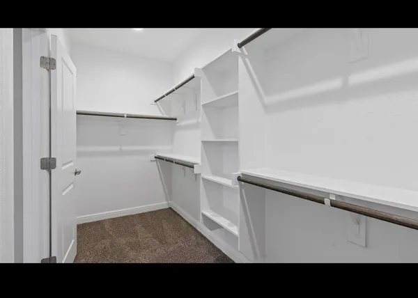 a view of walk in closet with empty racks