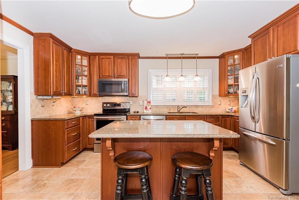 1001 Lansdowne Road Charlotte, NC 28270 - Photo 12 of 37 a kitchen with stainless steel appliances a stove a sink refrigerator and a cabinets