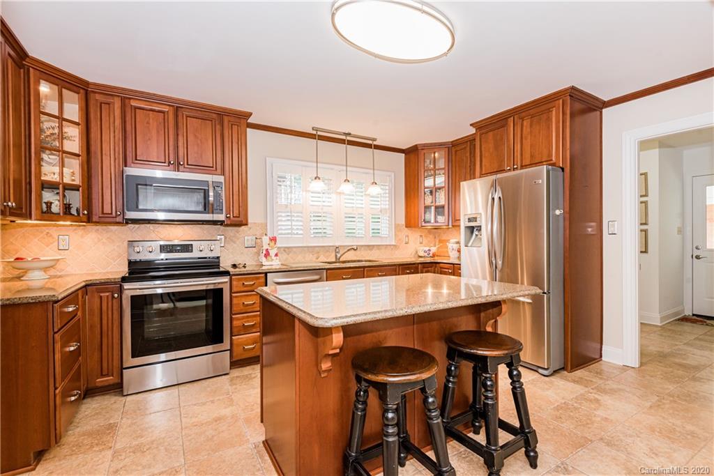 1001 Lansdowne Road Charlotte, NC 28270 - Photo 13 of 37 a kitchen with stainless steel appliances a stove a refrigerator and a stove top oven