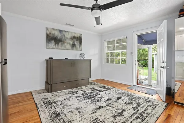 a view of a bedroom with wooden floor and windows
