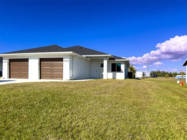 a front view of house with yard and trees in the background