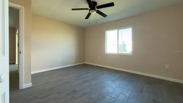 a view of an empty room with wooden floor