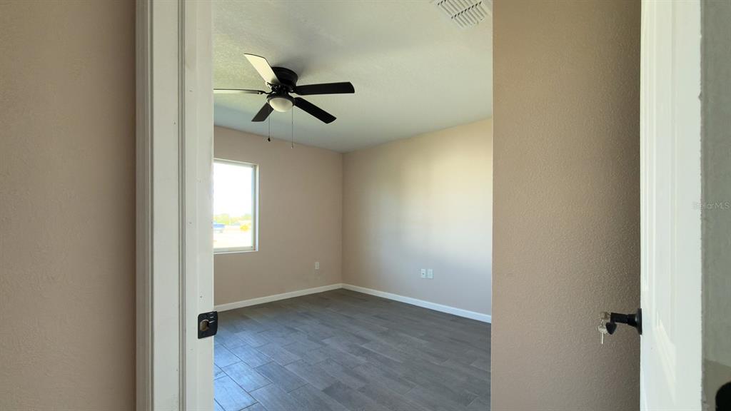 11154 Pendleton Avenue Englewood, FL 34224 - Photo 29 of 32 a view of empty room with wooden floor and fan