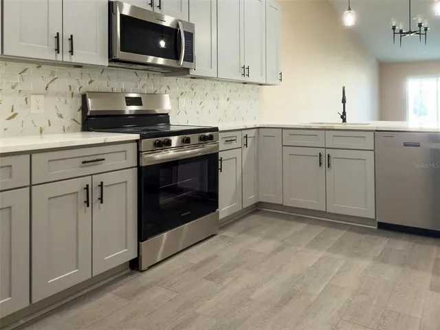 a kitchen with a sink stainless steel appliances and cabinets