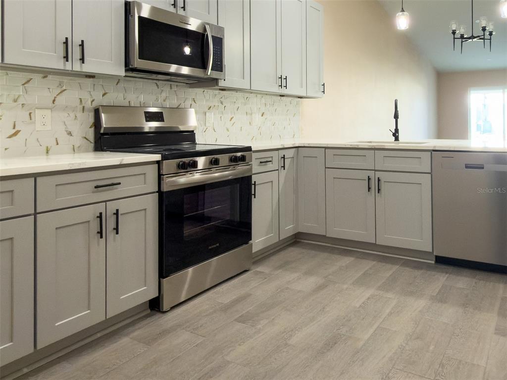 11154 Pendleton Avenue Englewood, FL 34224 - Photo 31 of 32 a kitchen with white cabinets stainless steel appliances and sink