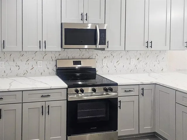 a kitchen with cabinets appliances and a sink