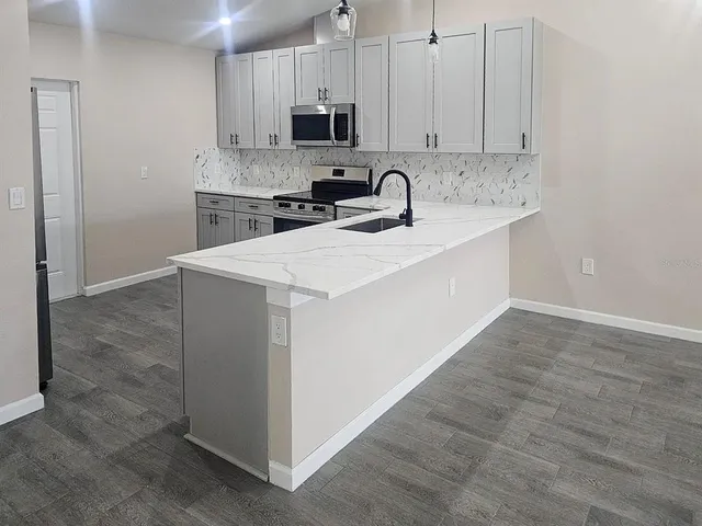 a kitchen with stainless steel appliances a sink stove and cabinets