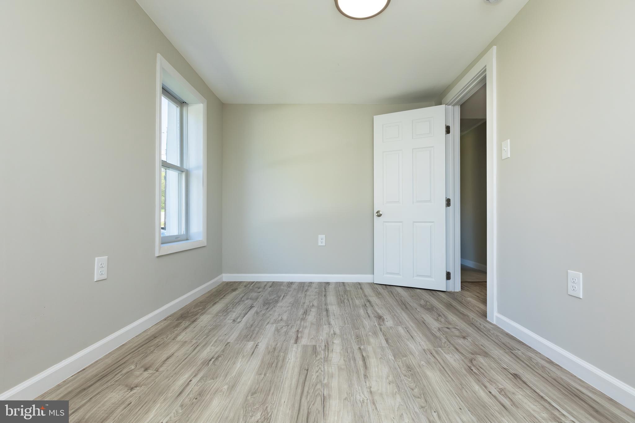 2407 Hammonds Ferry Road Halethorpe, MD 21227 - Photo 36 of 43 a view of an empty room with wooden floor and a window