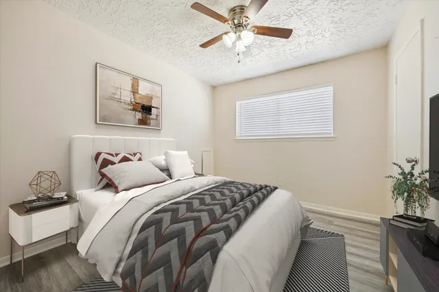 a bedroom with a bed and a potted plant