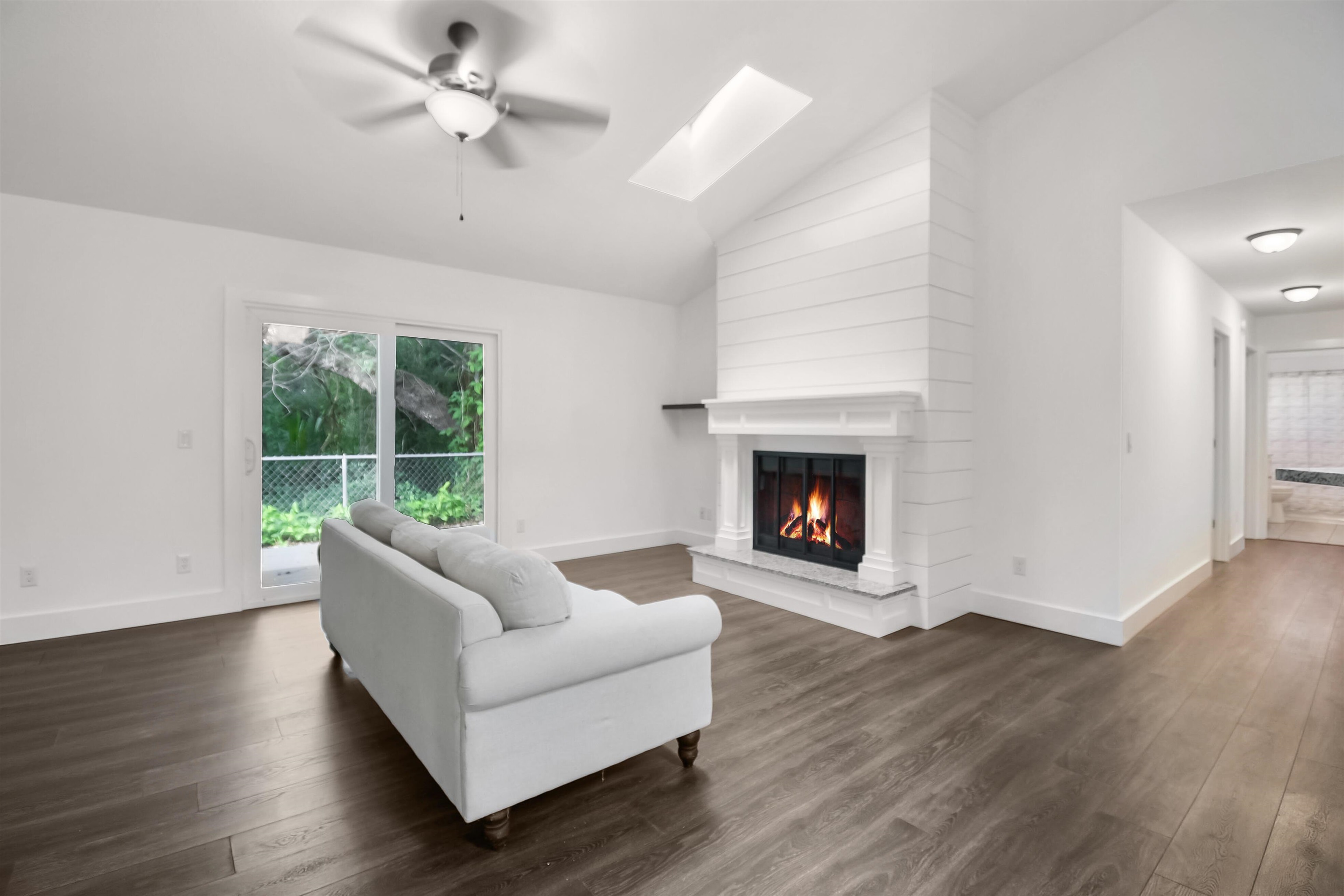 497 Pyrus Street St. Augustine, FL 32080 - Photo 3 of 36 Living room with lofted ceiling, a skylight, ceiling fan, plenty of natural light, and dark wood-style flooring