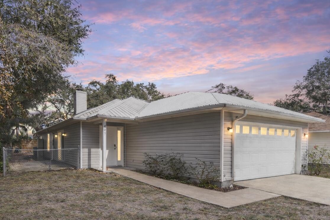 497 Pyrus Street St. Augustine, FL 32080 - Photo 35 of 36 View of front of home with a chimney, an attached garage, driveway, and a metal roof