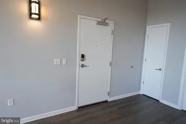 a view of a kitchen with refrigerator and wooden floor