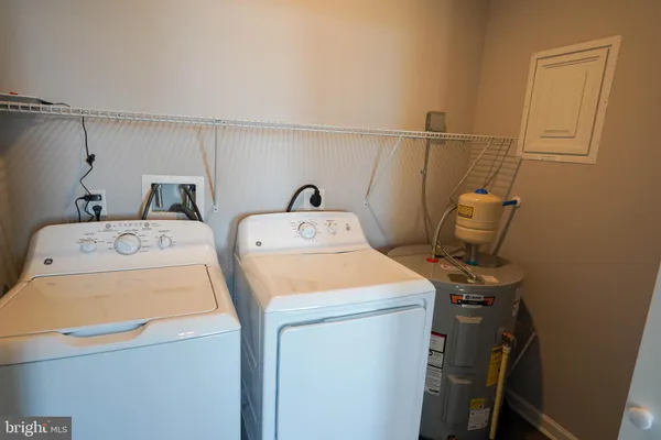 a kitchen with a sink a refrigerator and white cabinets