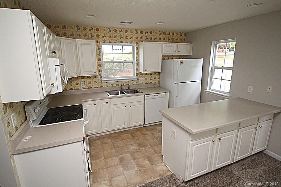 10503 Prairie Ridge Lane Charlotte, NC 28213 - Photo 4 of 9 a kitchen with white cabinets and white appliances