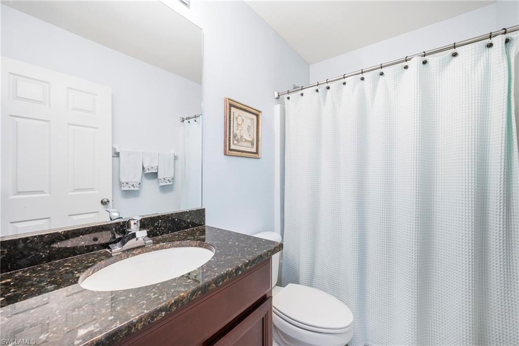 3916 Cherrybrook Loop Fort Myers, FL 33966 - Photo 17 of 31 Bathroom featuring a vanity with an integrated oval sink, a dark speckled countertop, and a chrome faucet