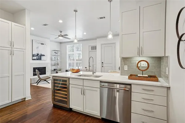 a kitchen with white cabinets and sink