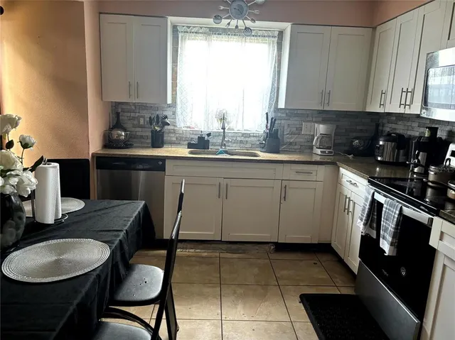 a view of a chairs and tables in the back yard of the house with a fire pit