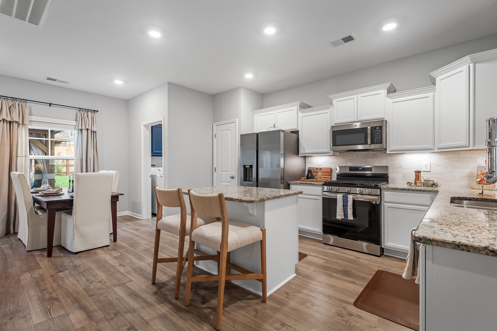 6004 Venable Court Fairview, TN 37062 - Photo 3 of 27 a kitchen with stainless steel appliances granite countertop a refrigerator a stove top oven a sink dishwasher a dining table and chairs with wooden floor