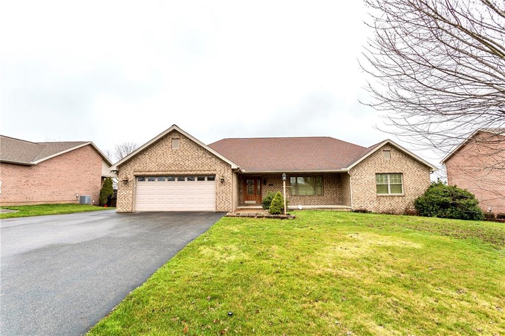 a view of a house with a yard and large tree