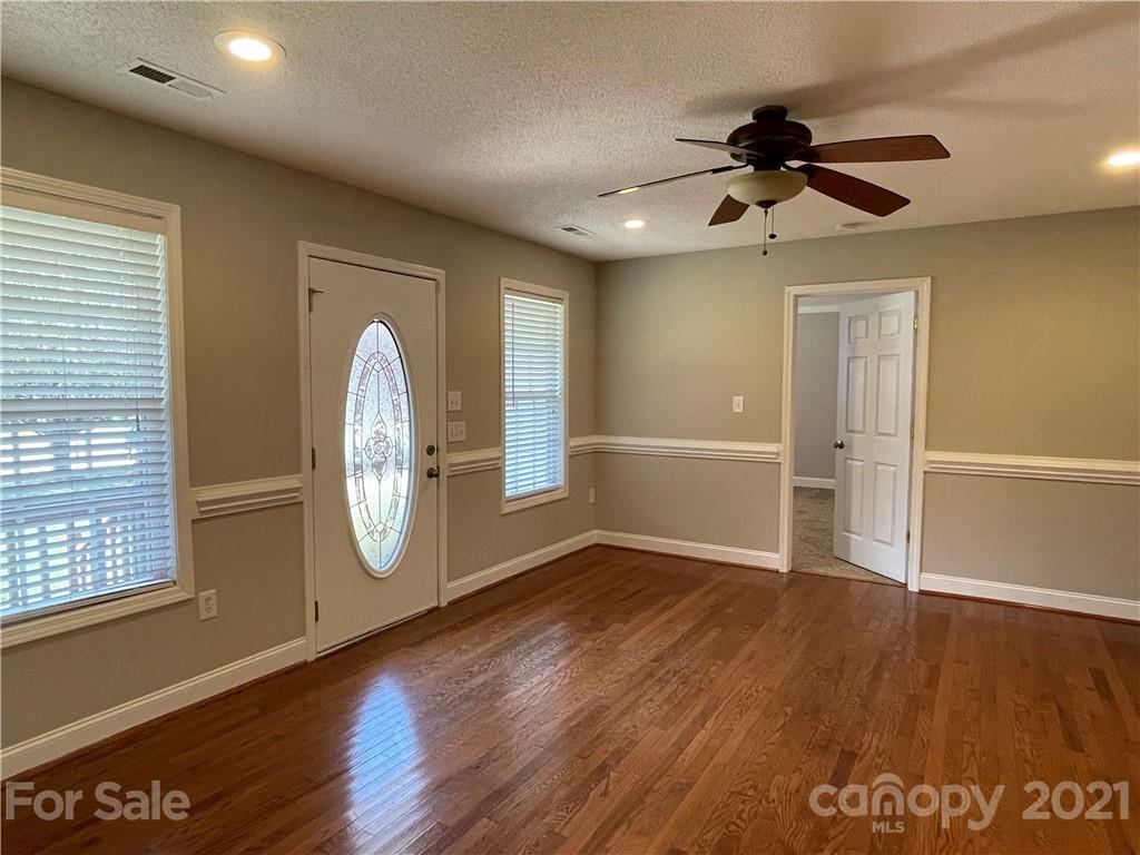3622 Lee Moore Road Maiden, NC 28650 - Photo 3 of 34 an empty room with wooden floor fan and windows