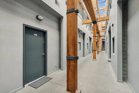 a view of a hallway with a glass door and furniture