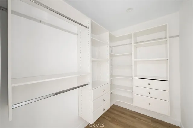 a view of walk in closet with empty racks