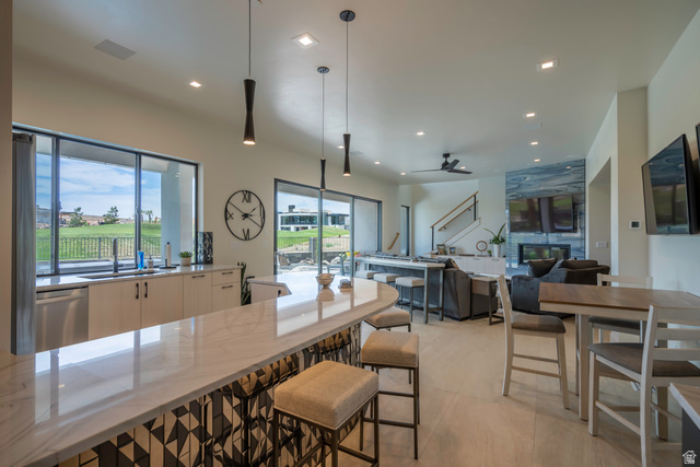 3606 South Cypress Road Hurricane, UT 84737 - Photo 61 of 69 Kitchen featuring light stone countertops, pendant lighting, stainless steel dishwasher, ceiling fan, and modern cabinets