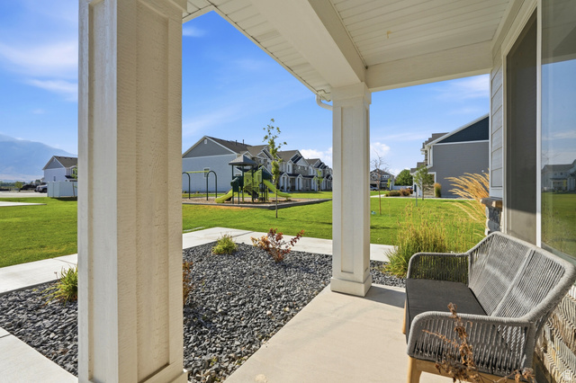 2216 South 1150 West Nibley, UT 84321 - Photo 3 of 34 Covered porch entry featuring white columns, a concrete walkway, and decorative rock landscaping