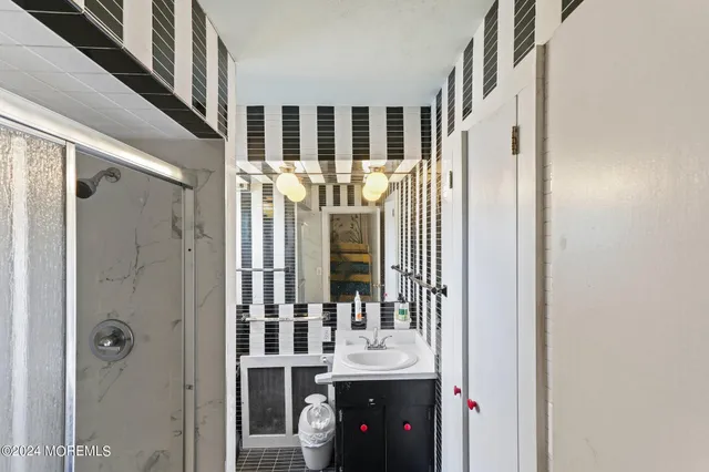 a bathroom with a shower a sink and a mirror