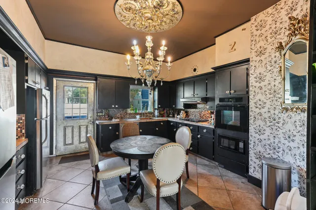 a kitchen with a dining table chairs stainless steel appliances and cabinets