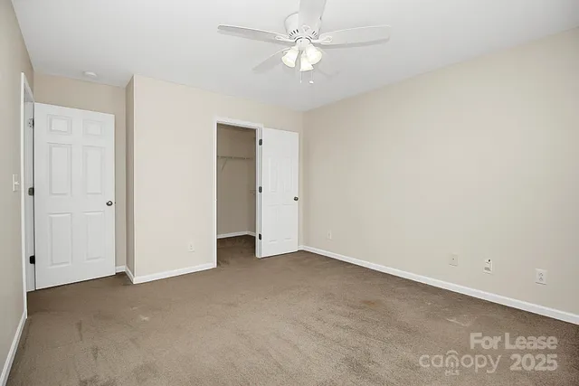 an empty room with a ceiling fan and a window