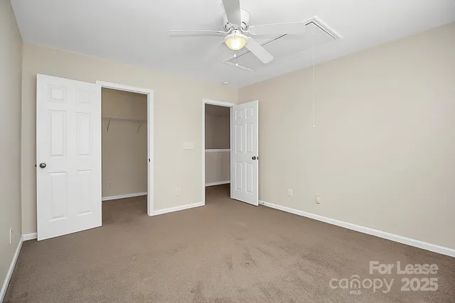 an empty room with a ceiling fan and a window