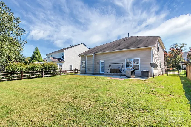 a view of a house with pool and chairs