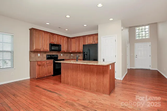 a kitchen with stainless steel appliances a refrigerator stove top oven and cabinets