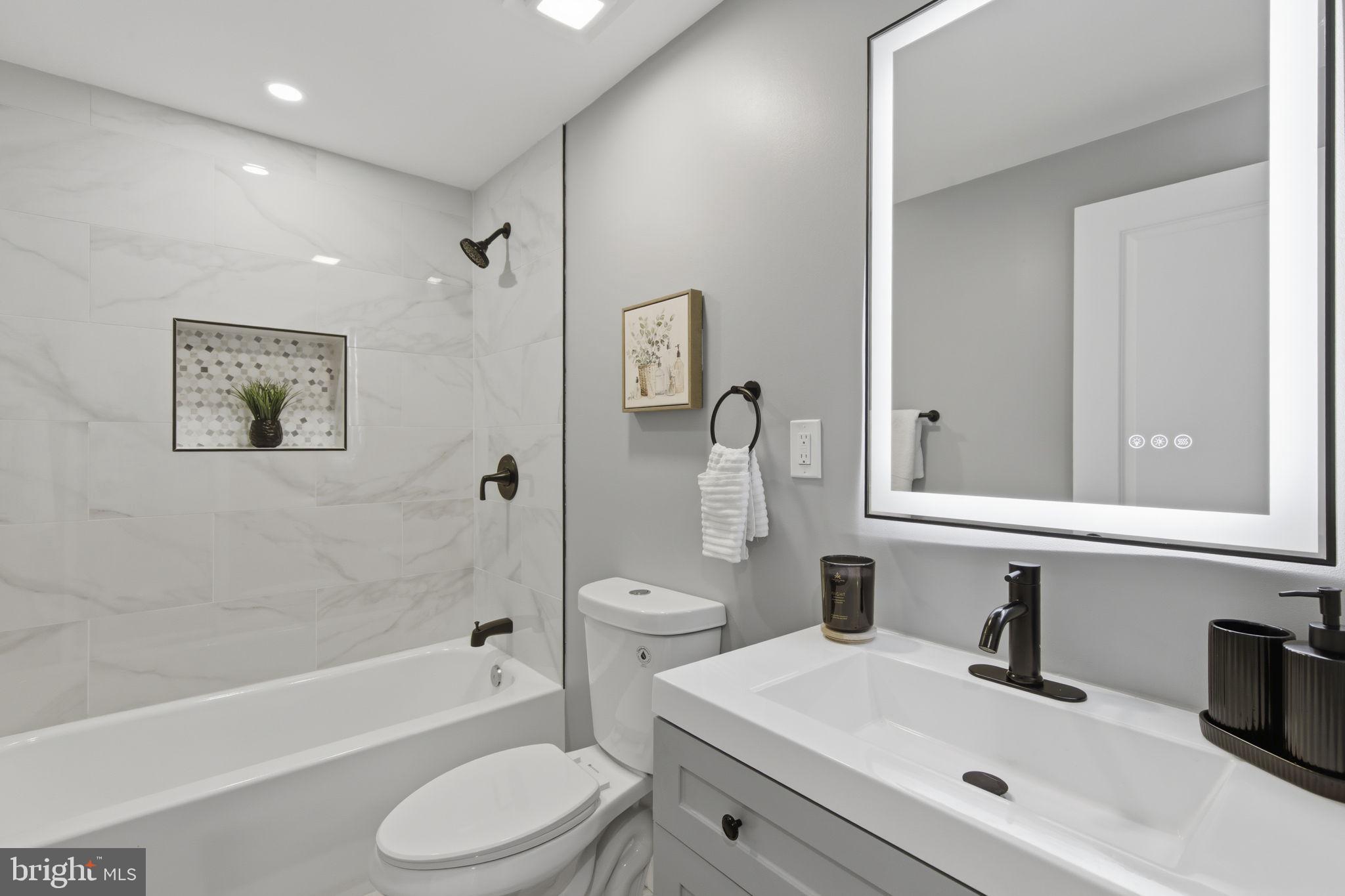 1600 Federal Street Baltimore, MD 21213 - Photo 16 of 31 a bathroom with a toilet a sink a mirror a bathtub and vanity
