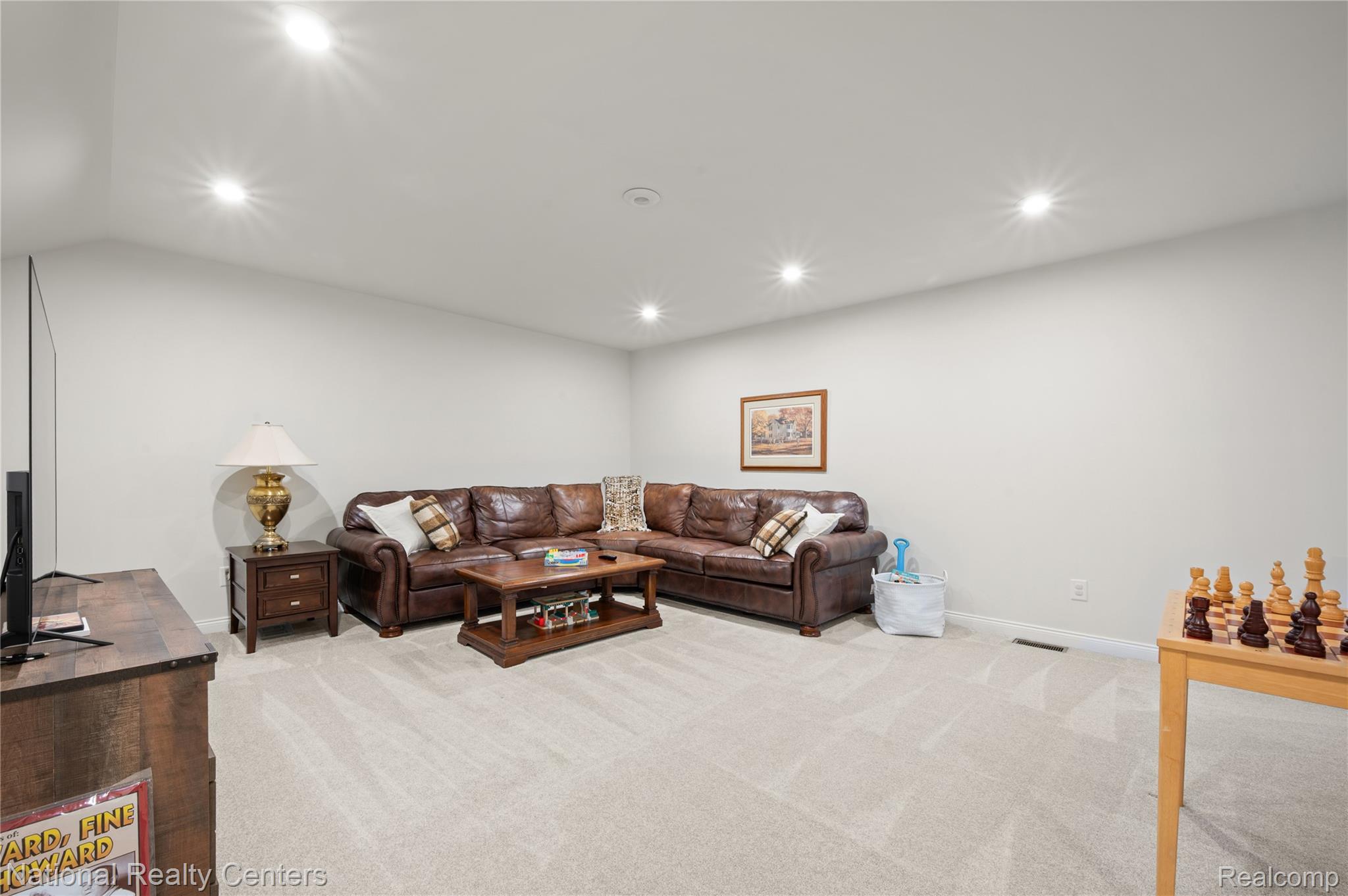 48796 Windfall Road Novi, MI 48374 - Photo 24 of 30 Spacious recreation room featuring light-toned carpeting, recessed lighting, and a vaulted ceiling