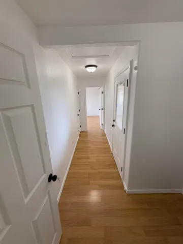 a view of a hallway with wooden floor and staircase